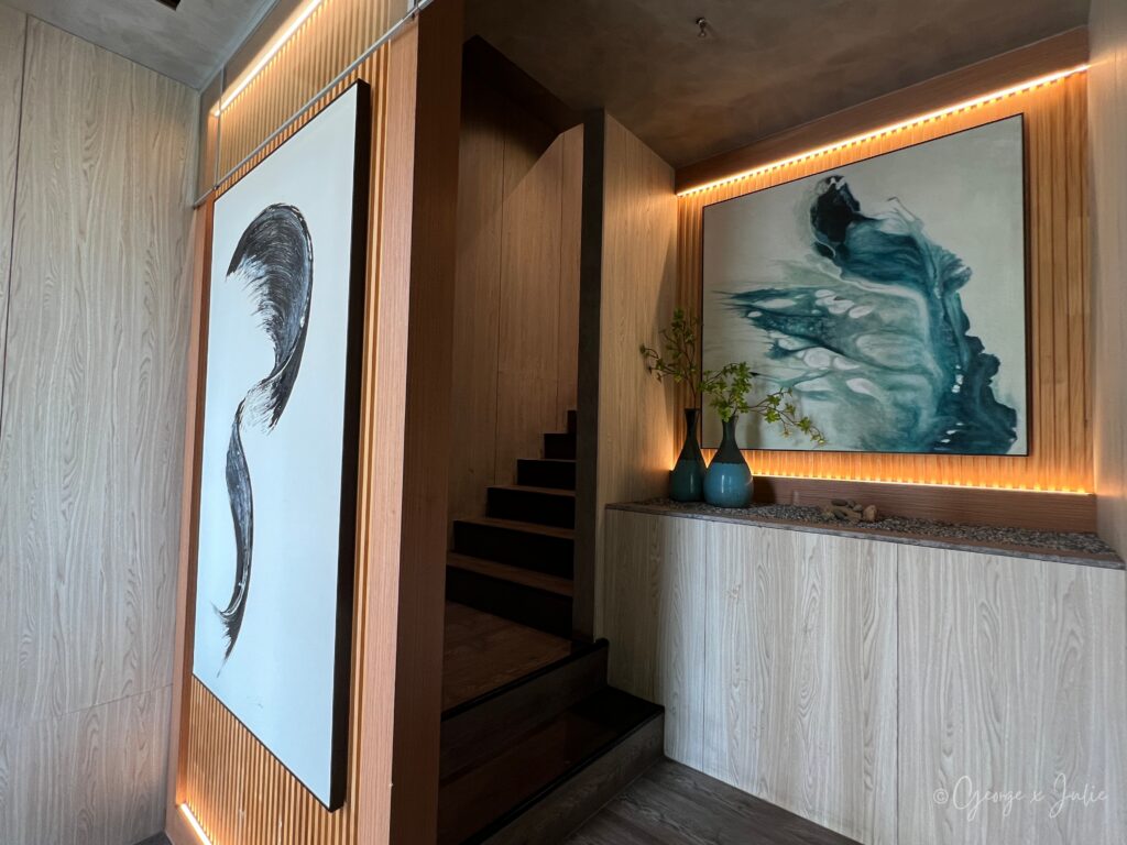 一鰭會玄關全景，水墨掛畫與藍色油畫並列，樓梯居中