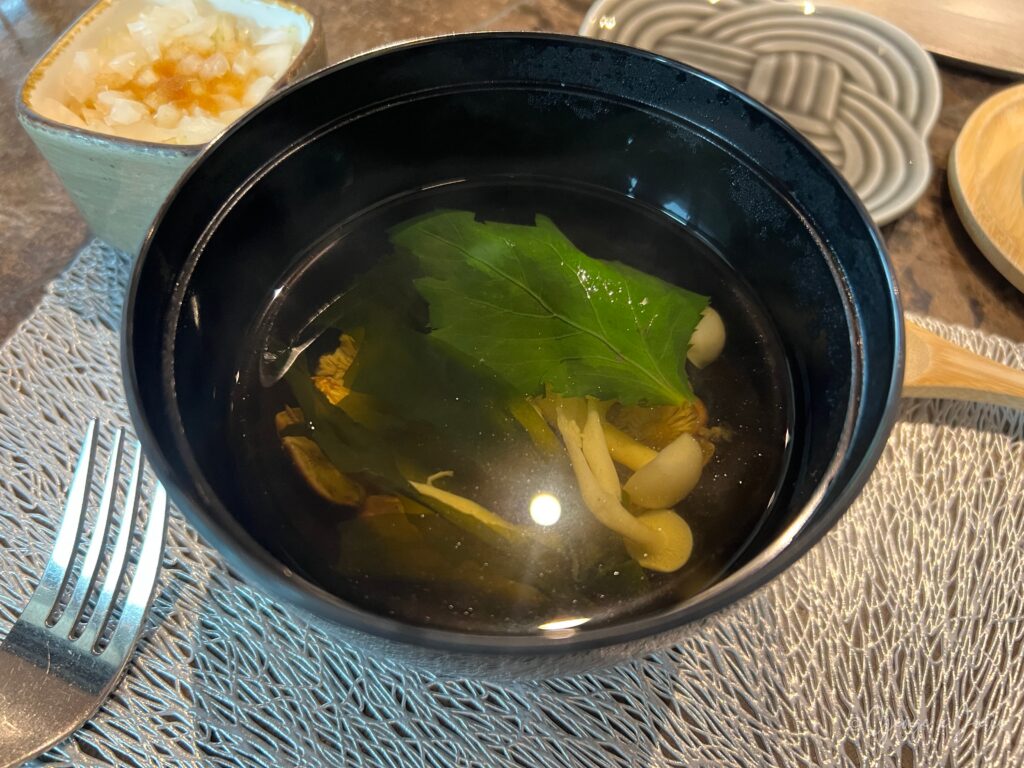 菌菇松茸湯，深色陶碗，金黃湯底