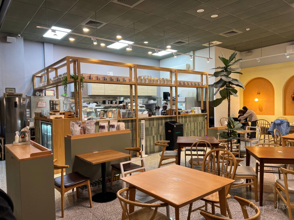 輕綠舍 Lite Canteen 室內用餐區，木質吧台、開放廚房、黃色拱門裝飾，青埔咖啡廳質感空間