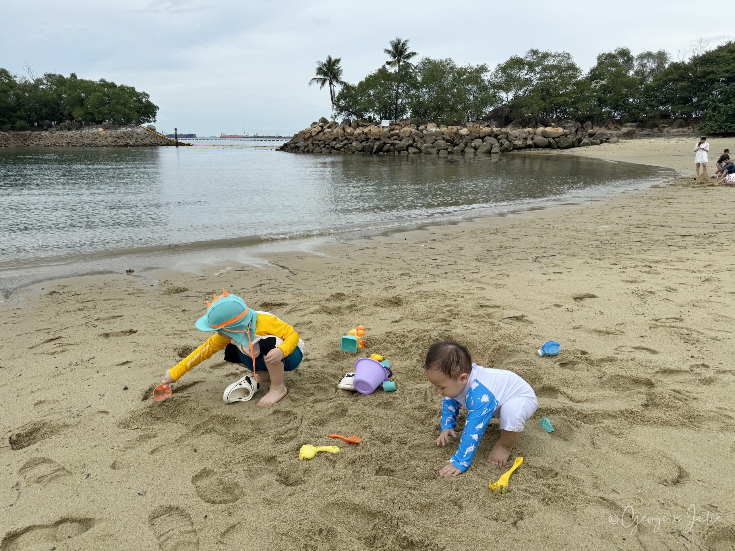 兩個孩子在海邊沙灘挖沙