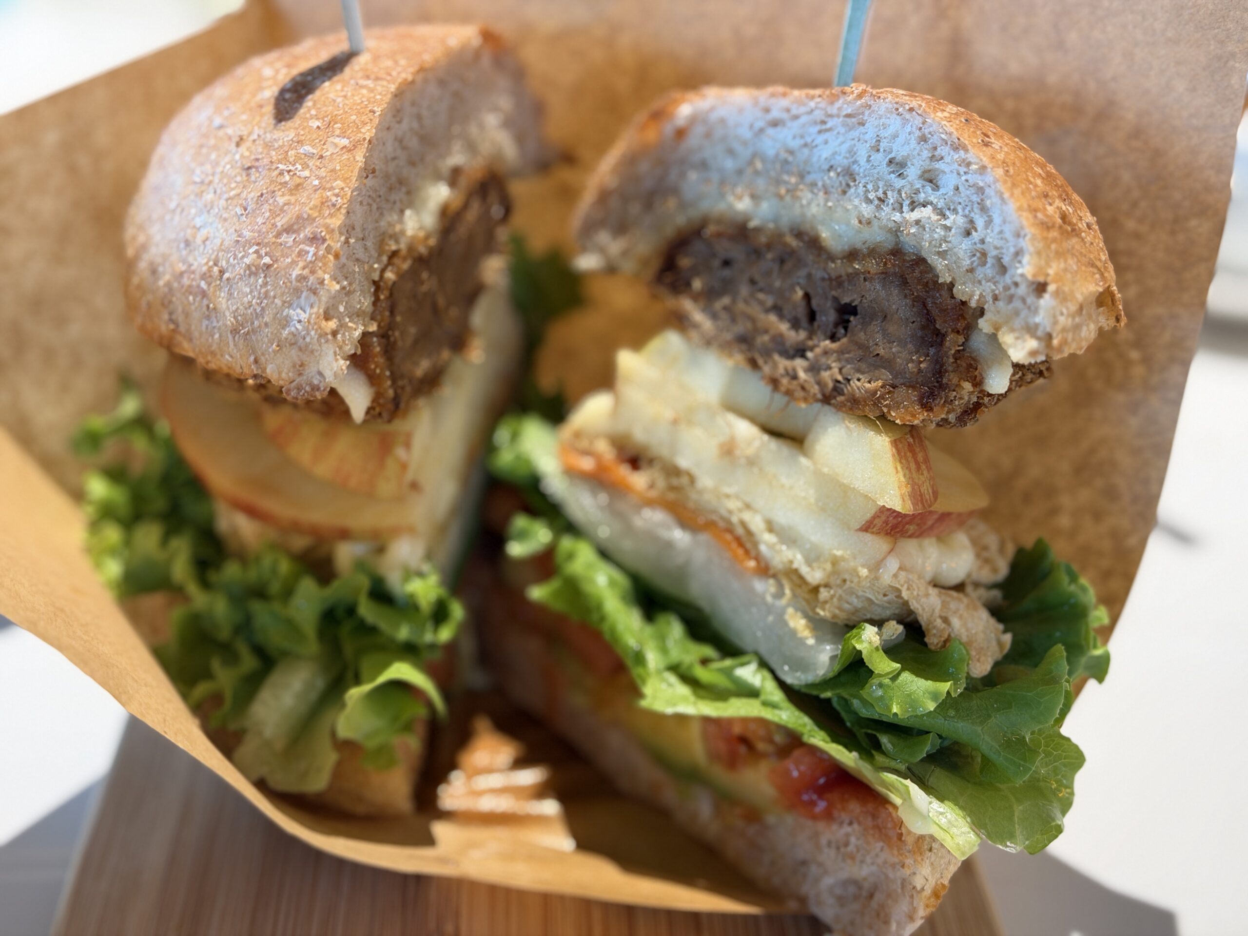 手拿咬開的酪梨菇菇堡，能看到菇類餅皮的斷面