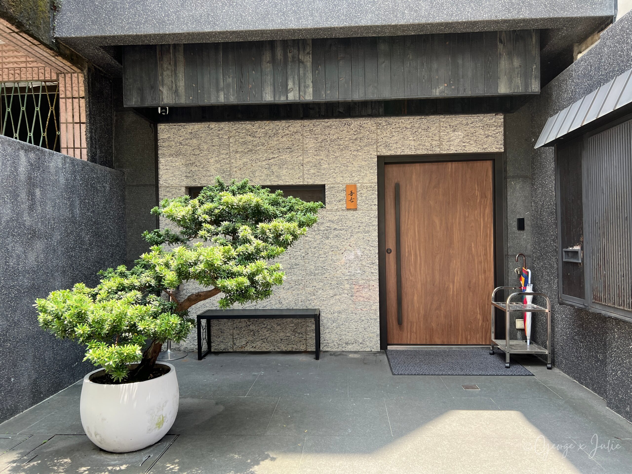 鮨吾七餐廳門口，日式木門配松樹盆栽