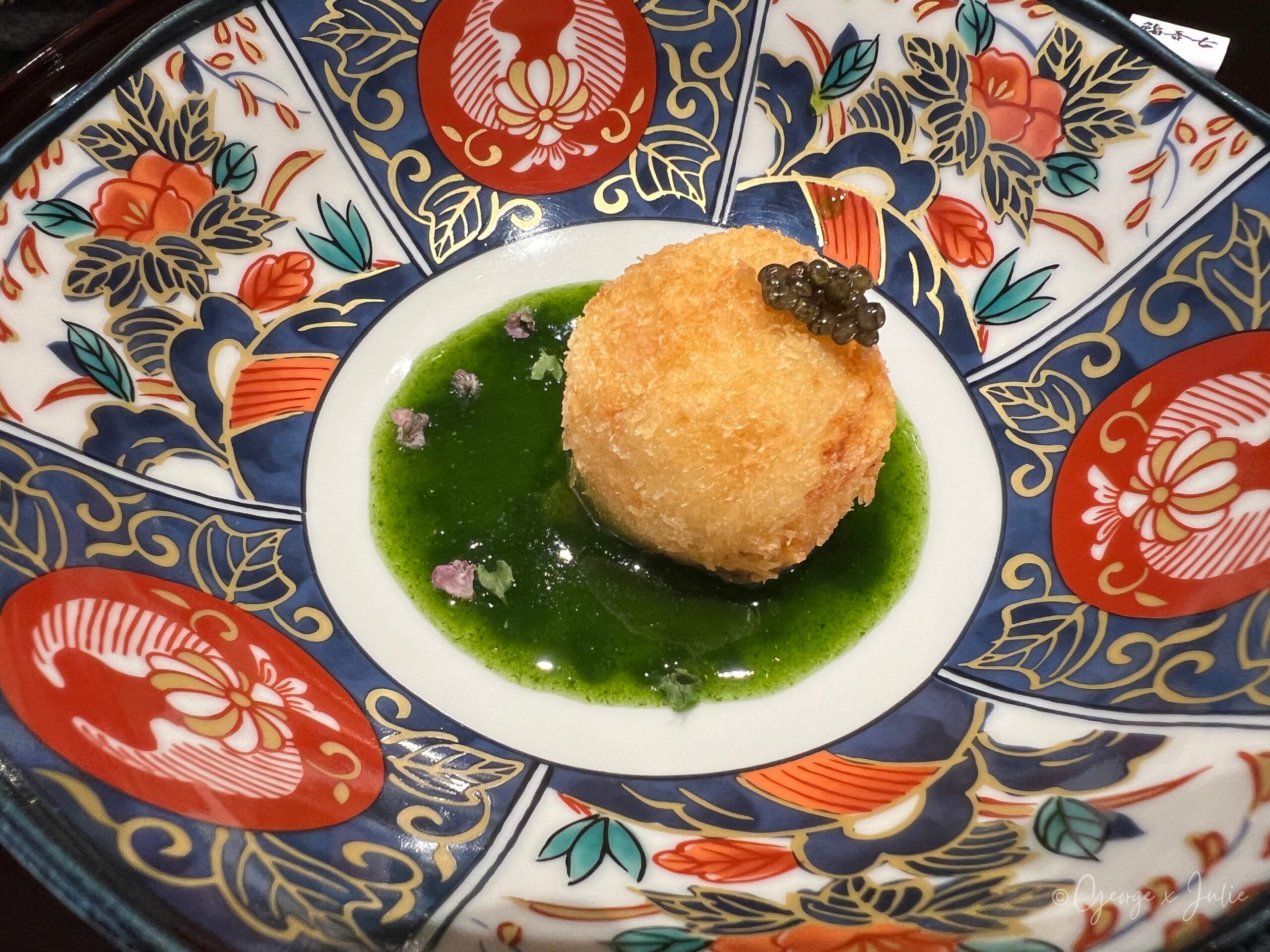 毛蟹可樂餅，外皮金黃，盛在鮮綠色菠菜芡汁的伊萬里燒大圓盤