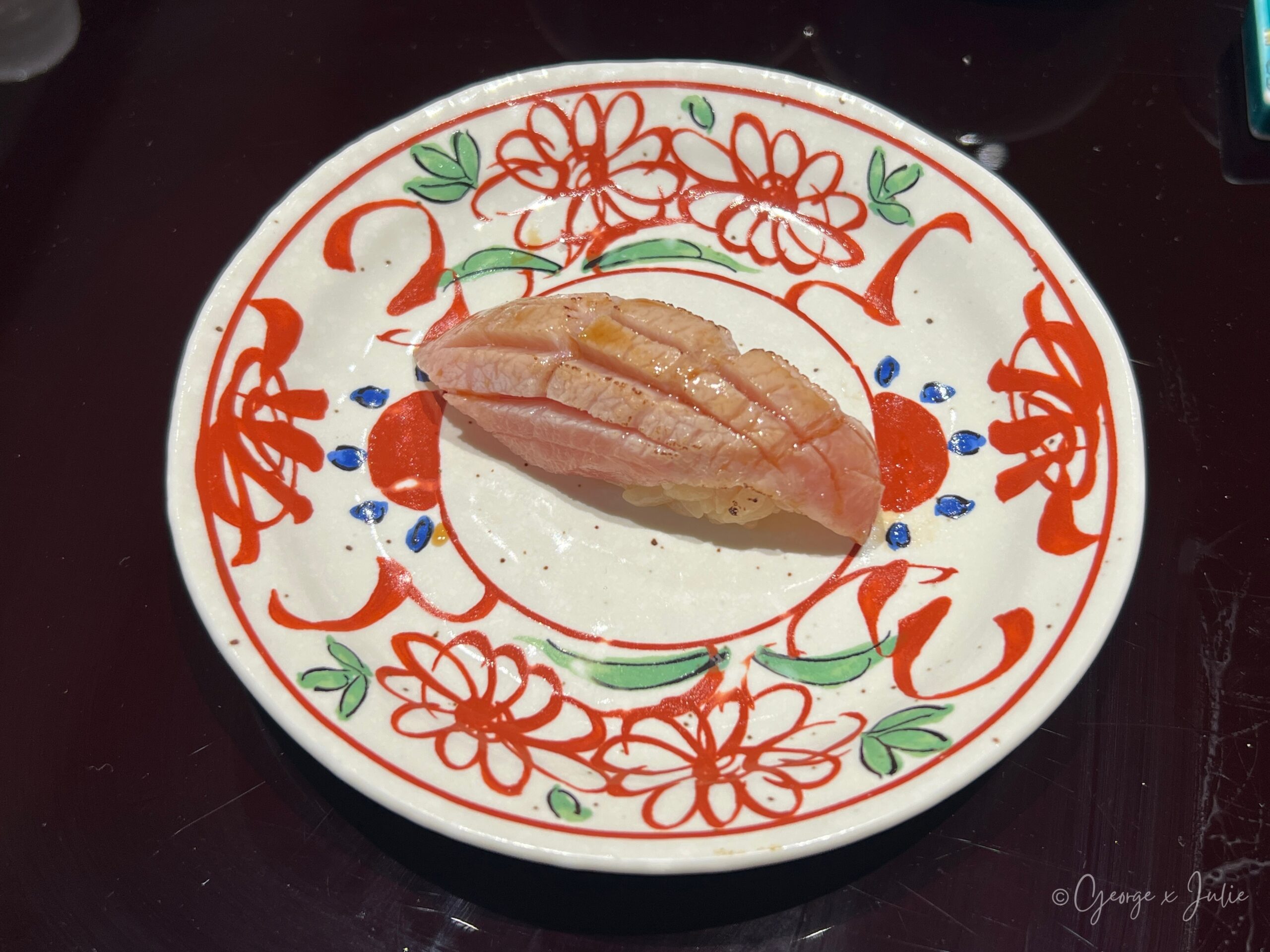 斐濟貝握壽司，淡粉白色貝肉，盛在花紋圓盤