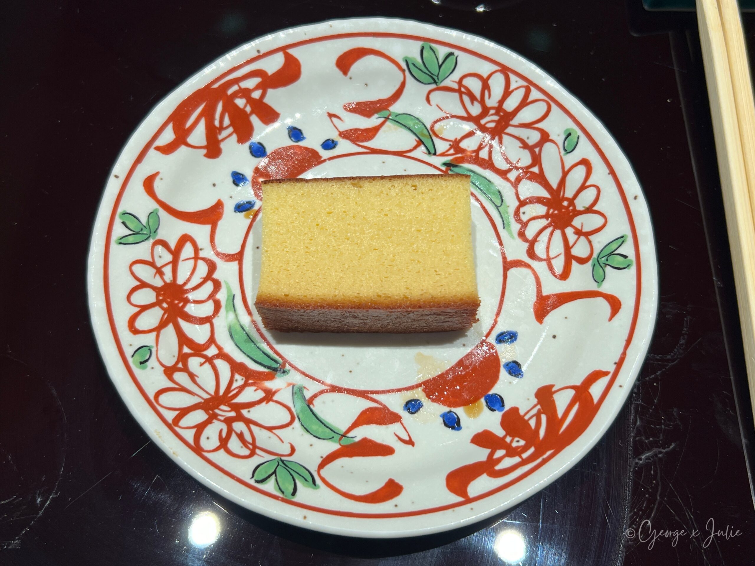 玉子燒，方形金黃色，口感像蜂蜜蛋糕，盛在紅花紋圓盤