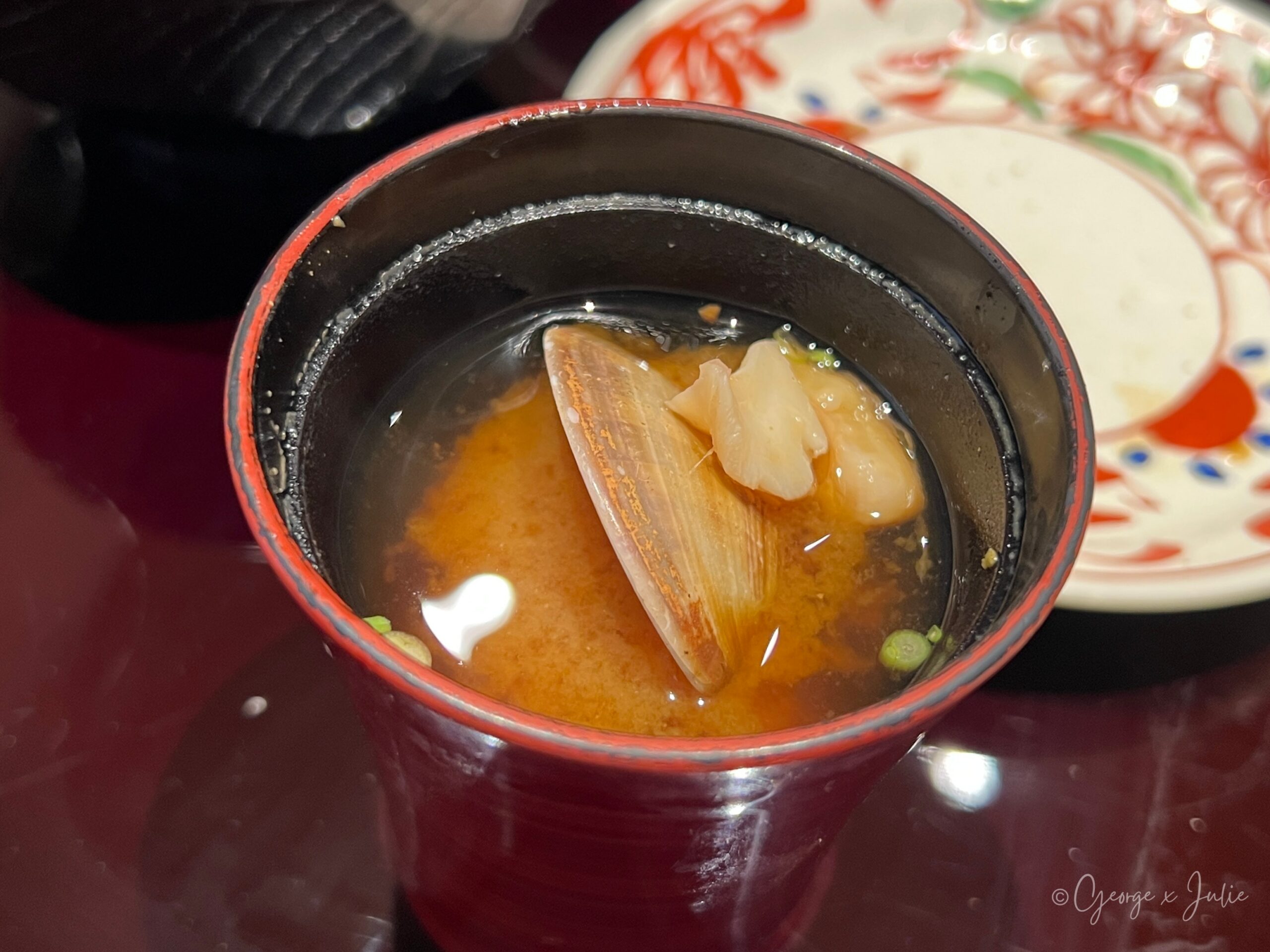 味噌汁，蛤蜊在漆碗中，湯色清澈琥珀