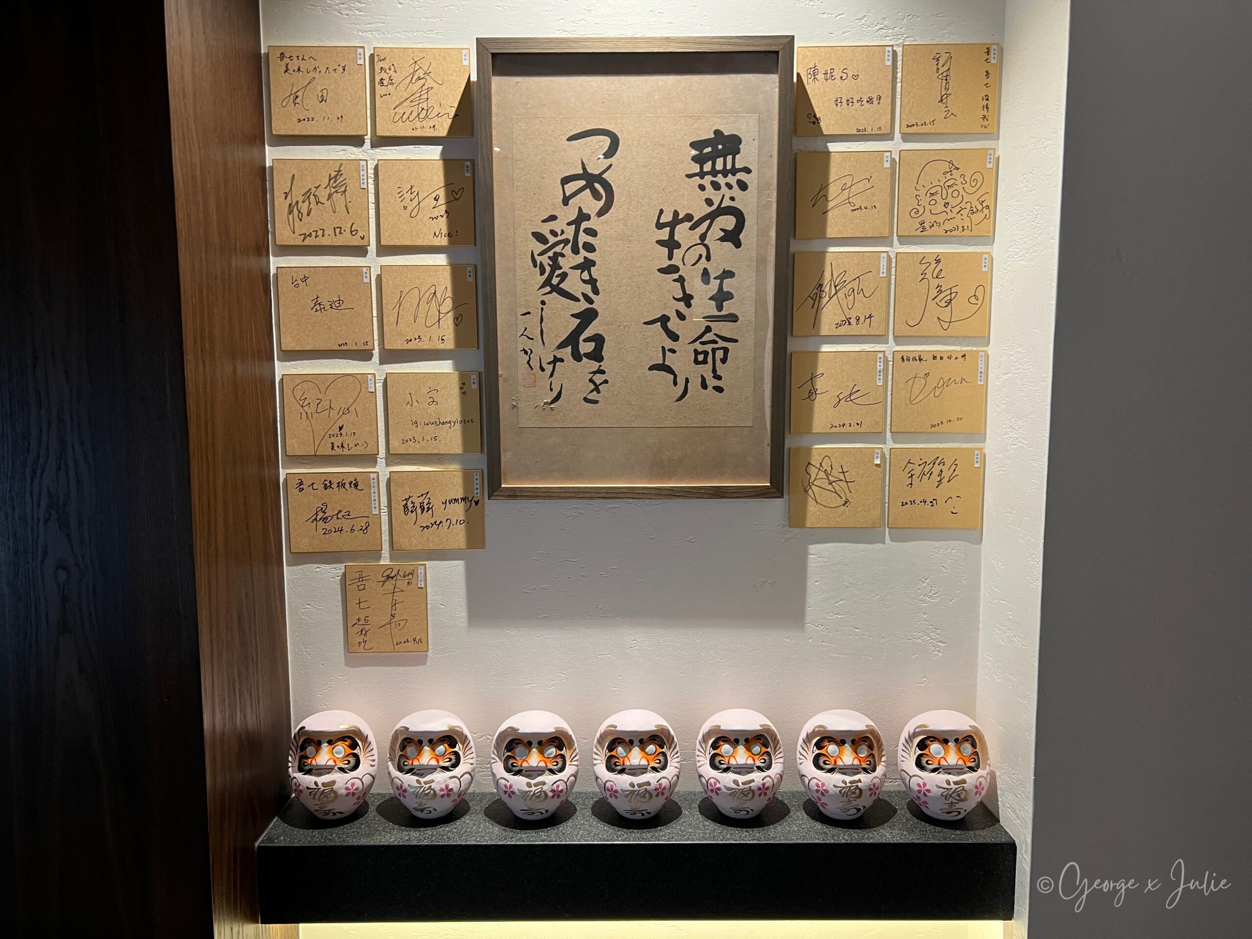 室內牆上的名人簽名板與七個達摩擺飾