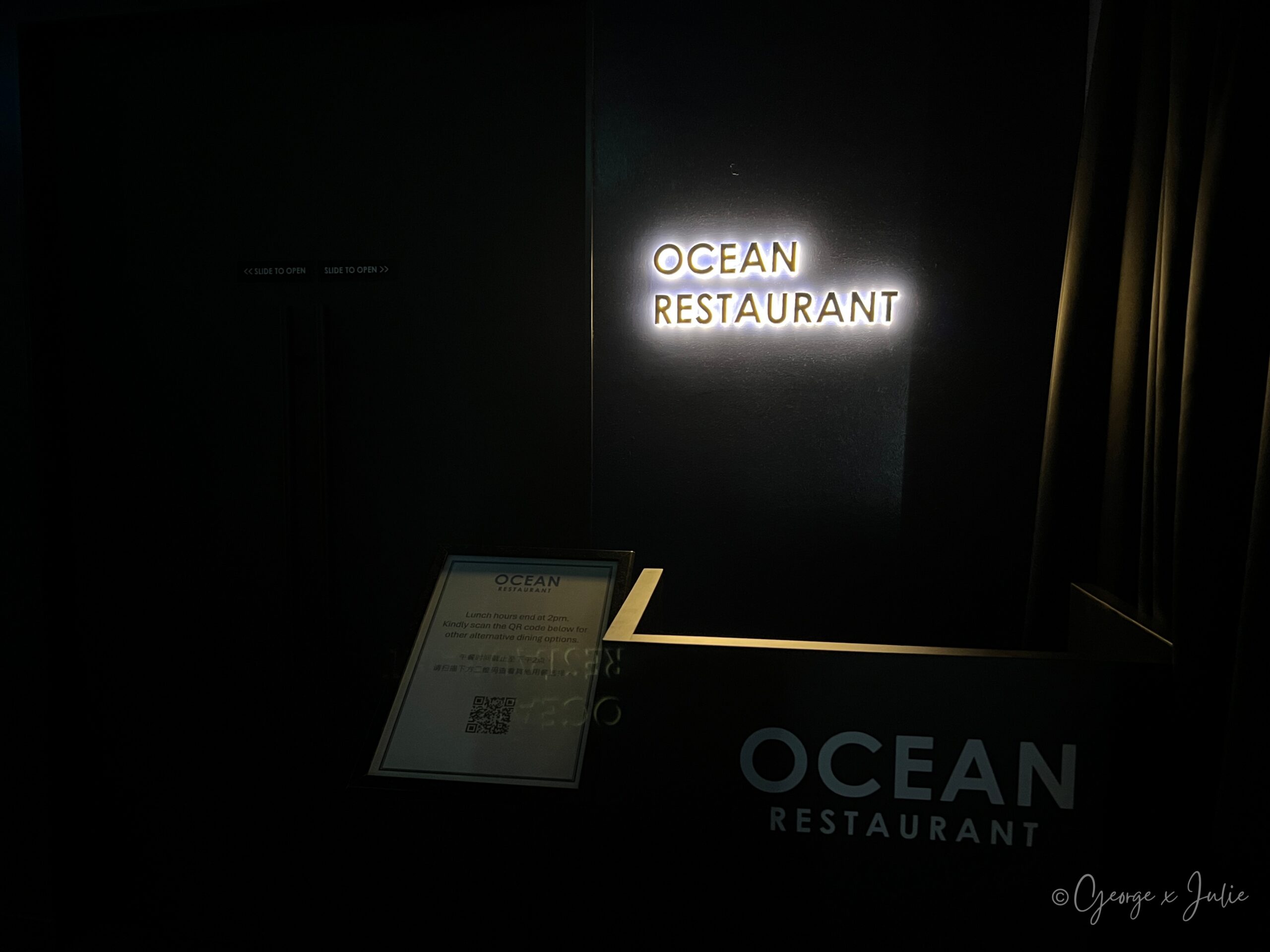 Ocean Restaurant入口招牌，暗色調牆面配金色OCEAN RESTAURANT字樣燈箱