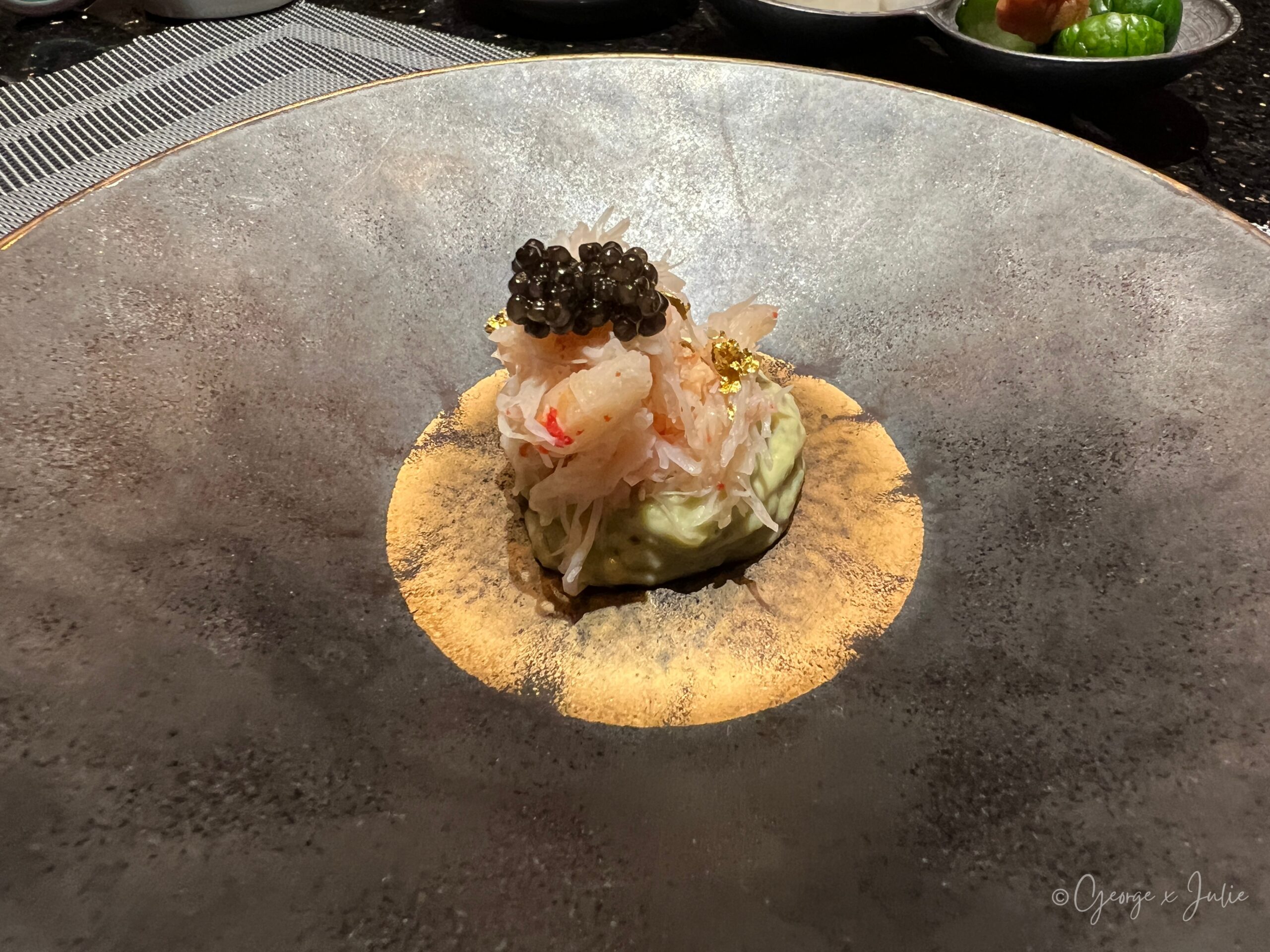 帝王蟹肉、魚子醬、金箔冷前菜，鋪在金箔圓盤上