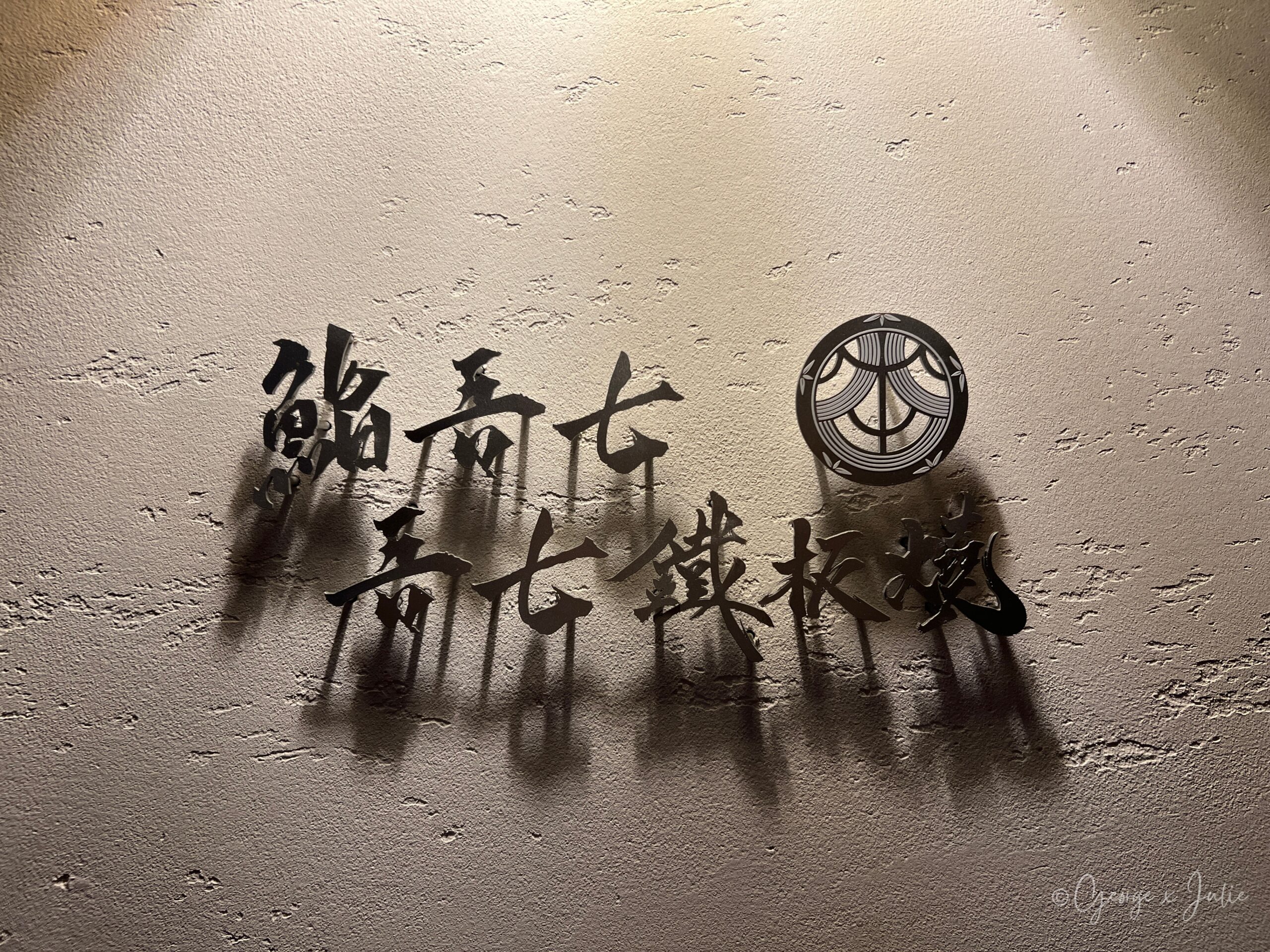 牆上「鮨吾七・吾七鐵板燒」金屬字與家紋