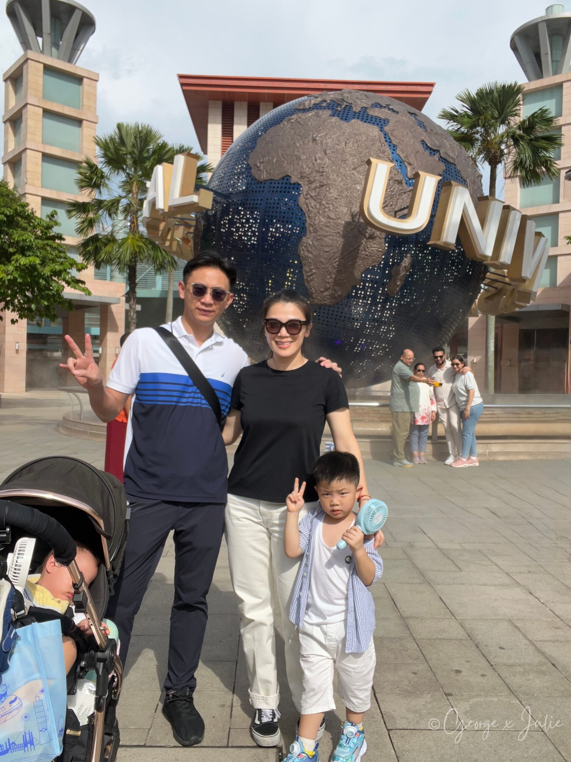 George、Julie與Jensen在環球影城招牌地球前合照，George比YA、Jensen也比著YA