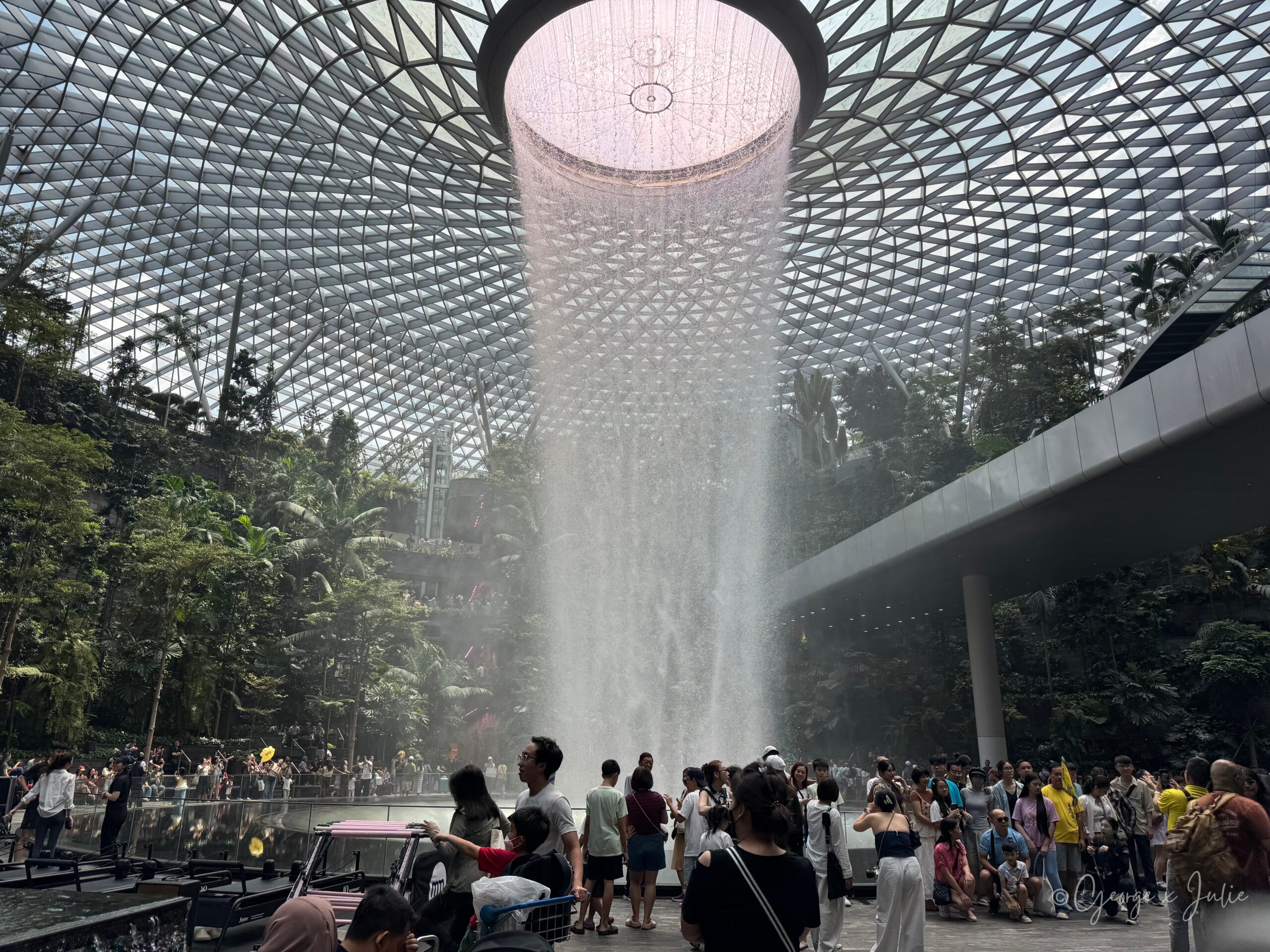 寄放完行李，準備去覓食的路上經過雨漩渦（Rain Vortex），近距離看瀑布從玻璃圓頂中央落下，旁邊擠滿拍照的旅客