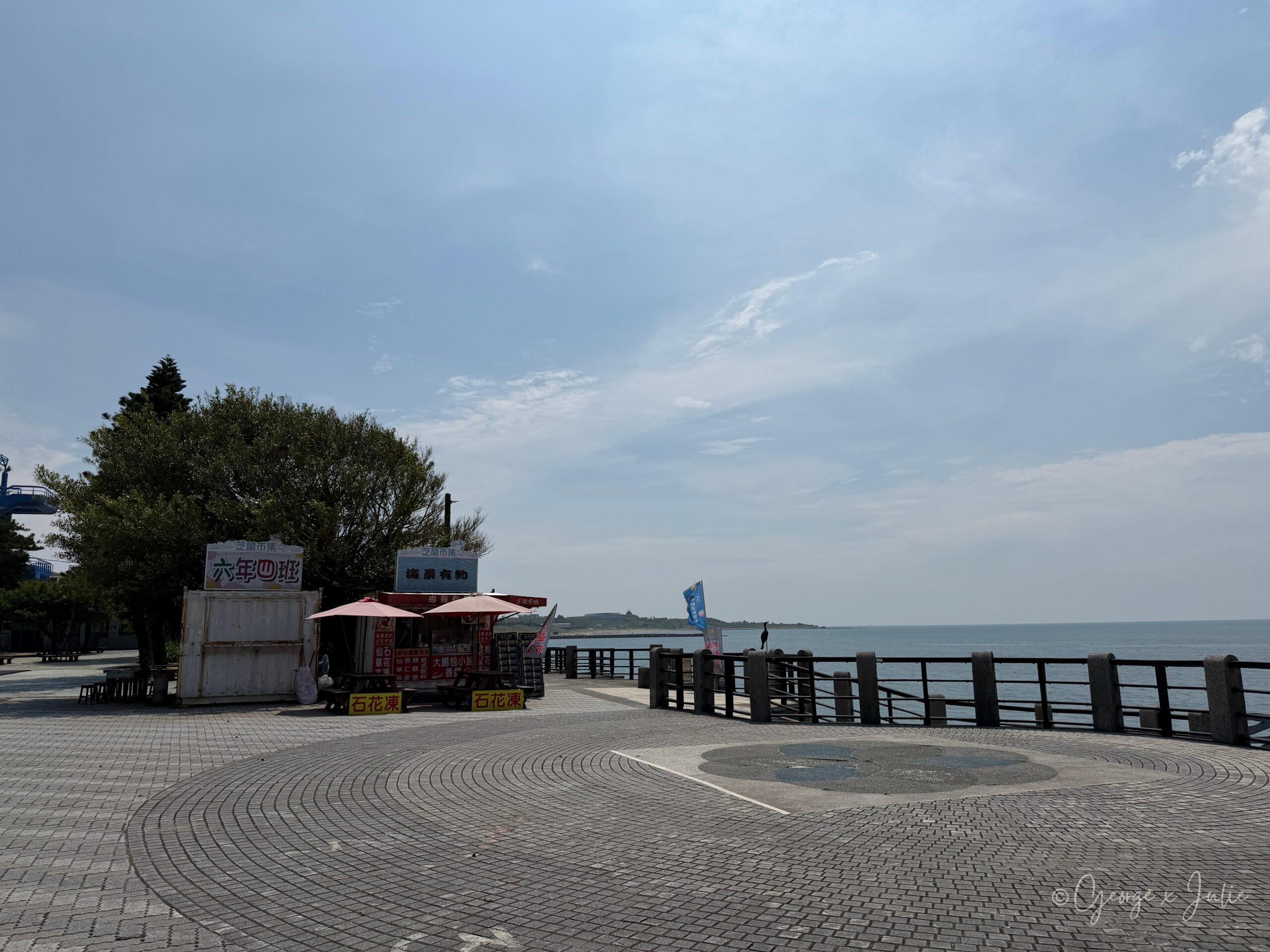 【新北三芝景點】芝蘭公園海上觀景平台|北海岸婚戒打卡海上步道 12 芝蘭公園廣場,一家撐紅色陽傘的營業攤位,背景是海景