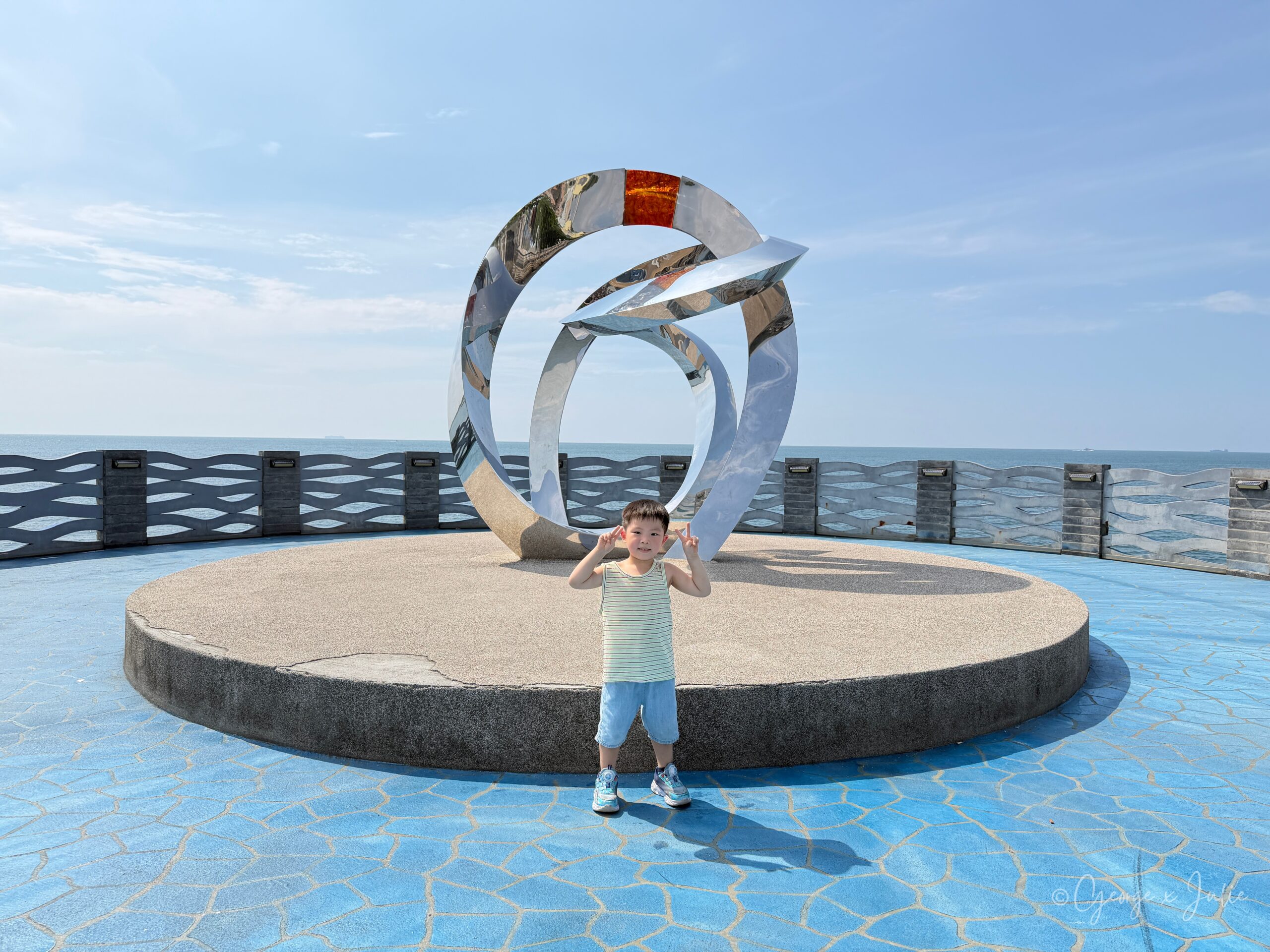 【新北三芝景點】芝蘭公園海上觀景平台|北海岸婚戒打卡海上步道 8 Jensen站在不鏽鋼婚戒裝置藝術前擺姿勢,背景是圓形平台與海景