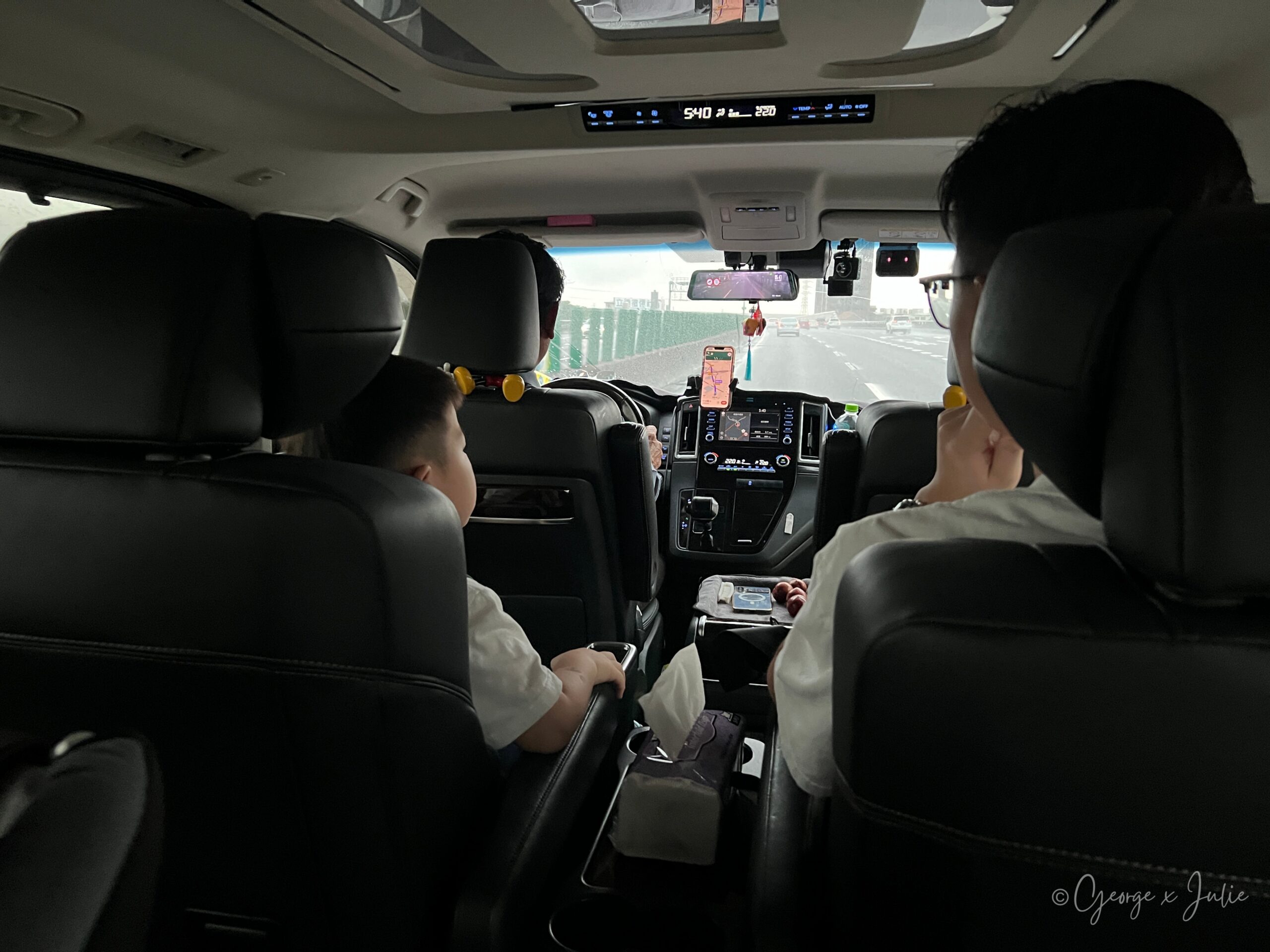 機場接送車上，Jensen 坐在中排座椅，George 在另一側看導航