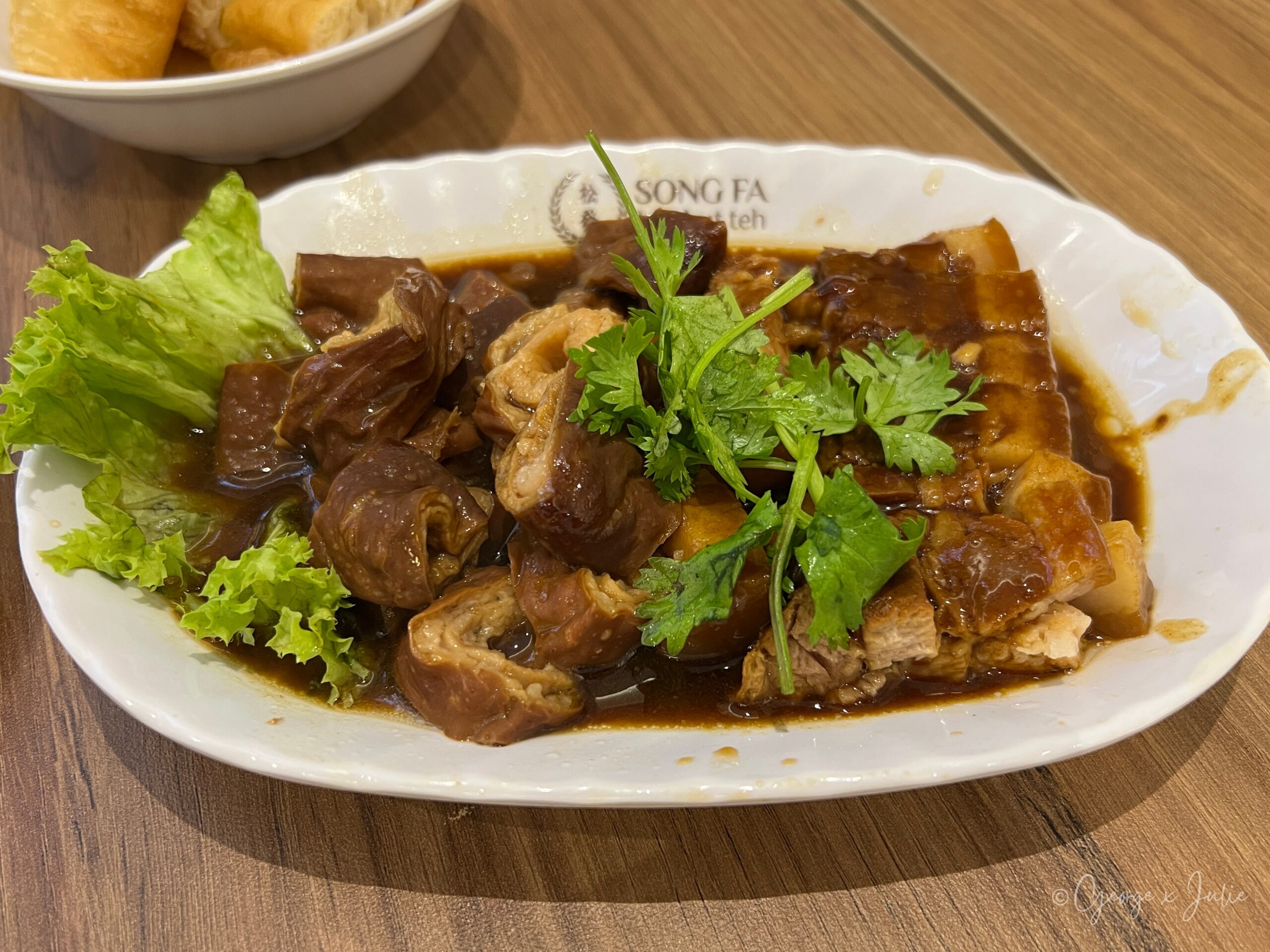 松發肉骨茶滷扣肉拼大腸拼盤，深色滷汁滷肉與大腸捲，鋪香菜與生菜