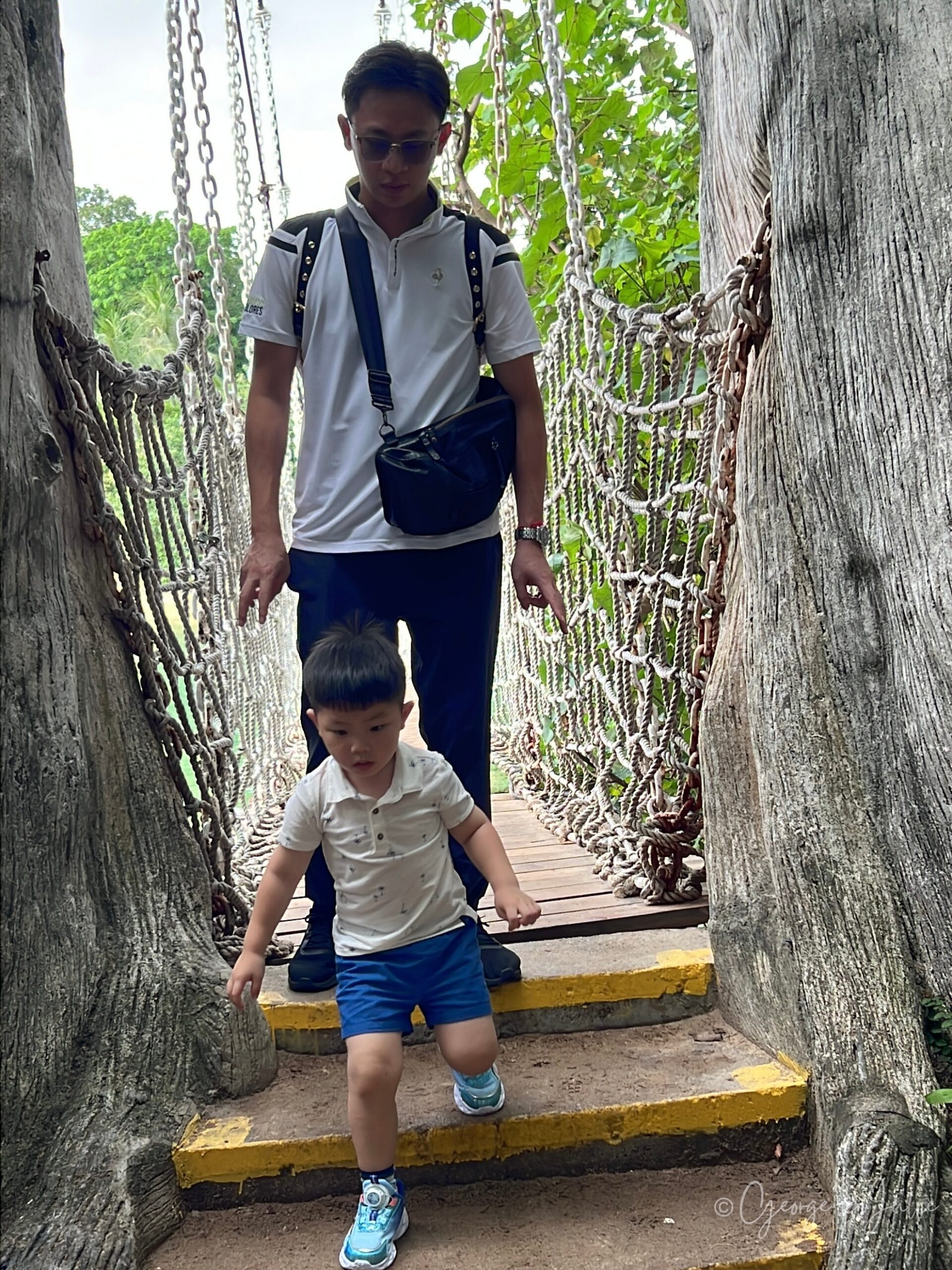 【新加坡景點】聖淘沙亞洲大陸最南端|Palawan Beach 90度椰子樹、吊橋免費踩點 10 吊橋尾端的木階梯,George 跟在後頭,Jensen 自己小心地走下階梯