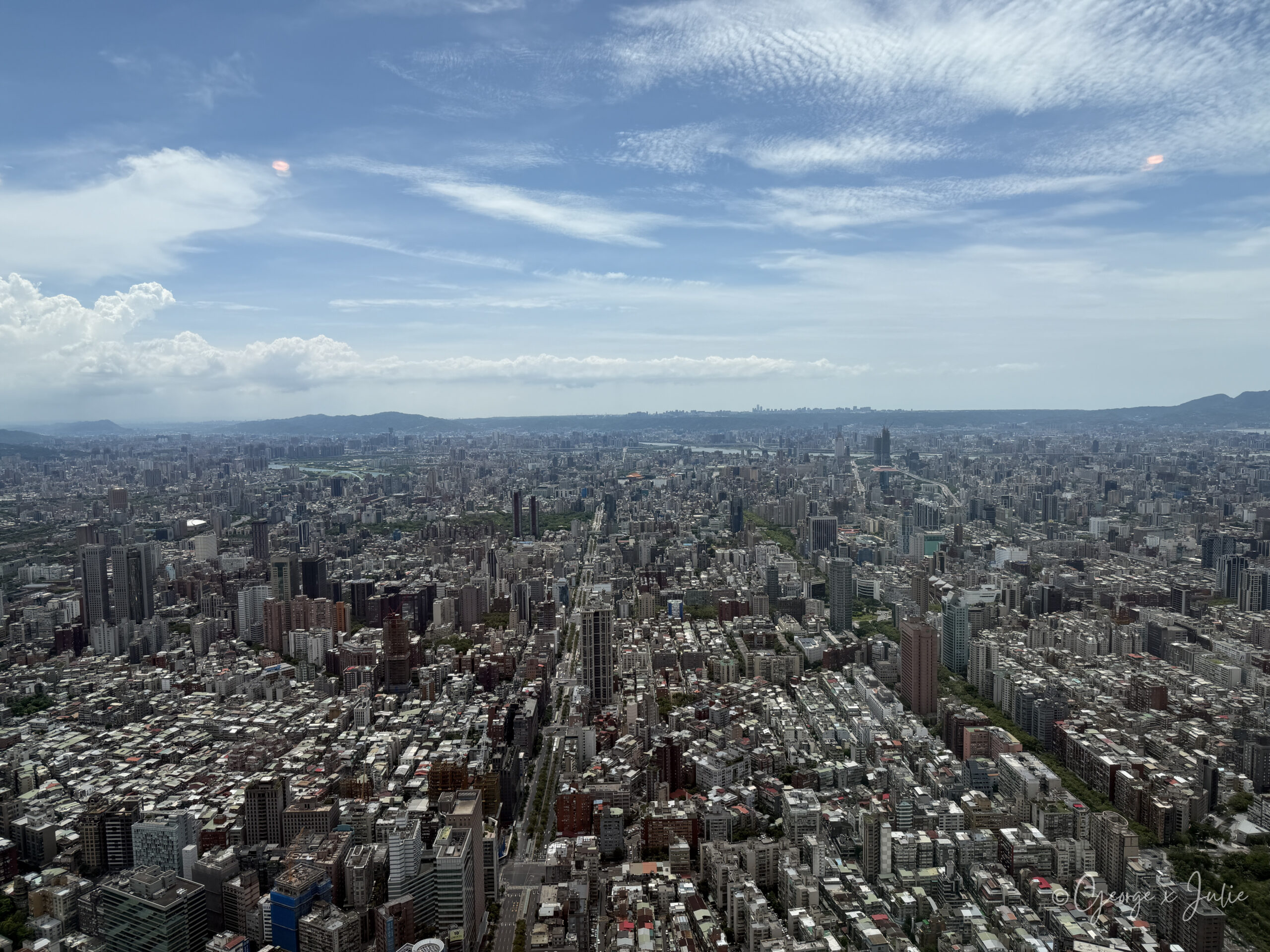 從台北101觀景台 89 樓望出去的台北市景，樓房一路延伸到遠方的山