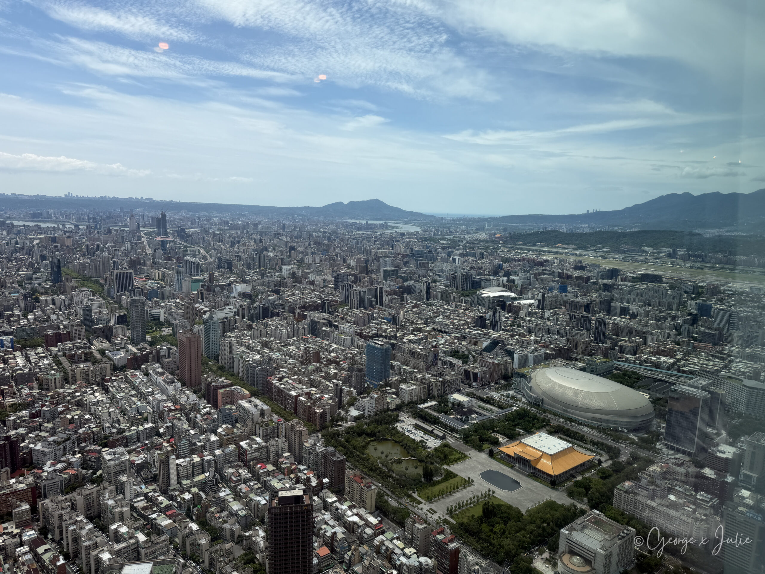 從台北101觀景台 89 樓看台北大巨蛋、國父紀念館與遠處的松山機場