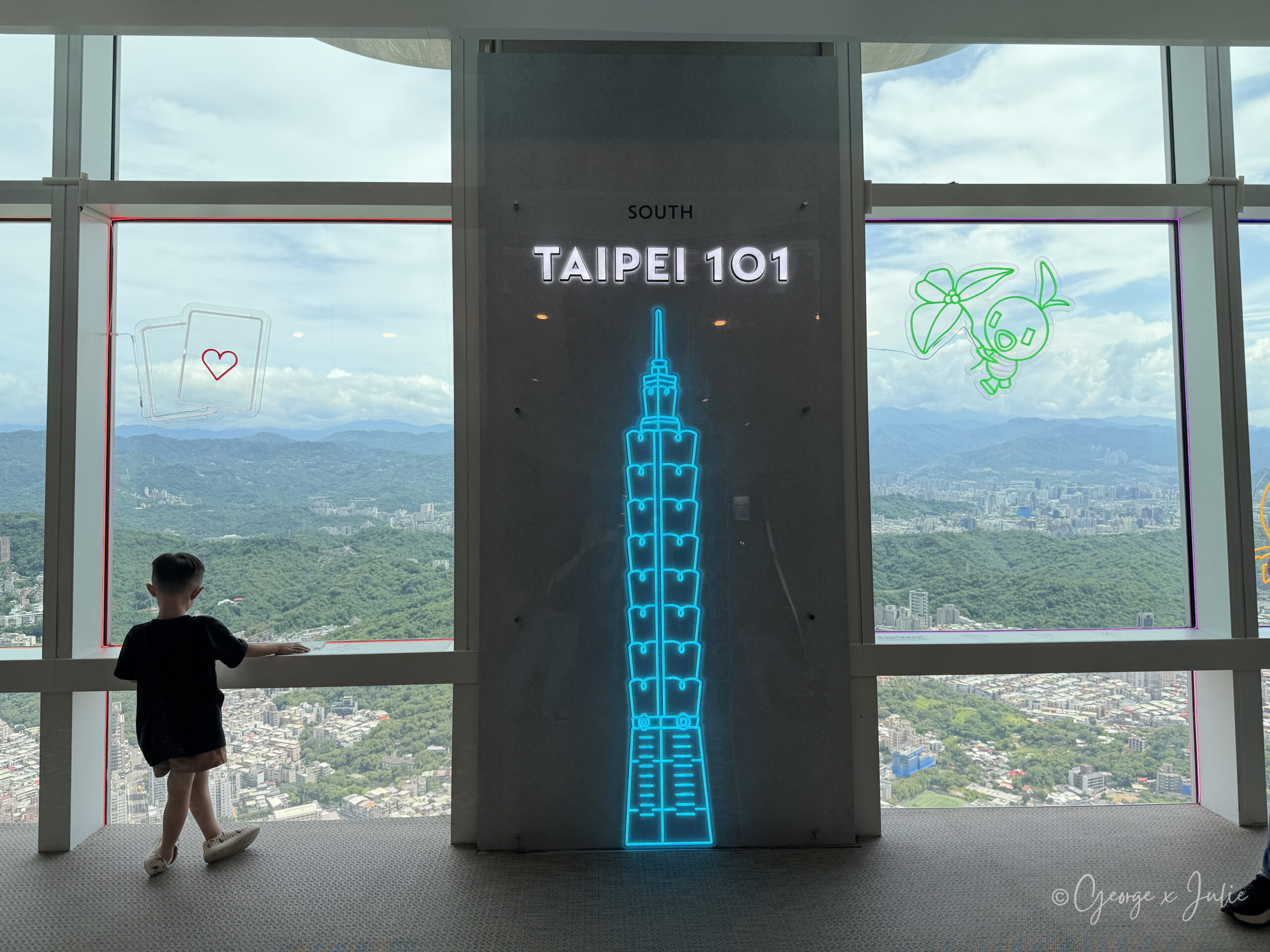 台北101觀景台南側窗邊的霓虹燈與窗外山景