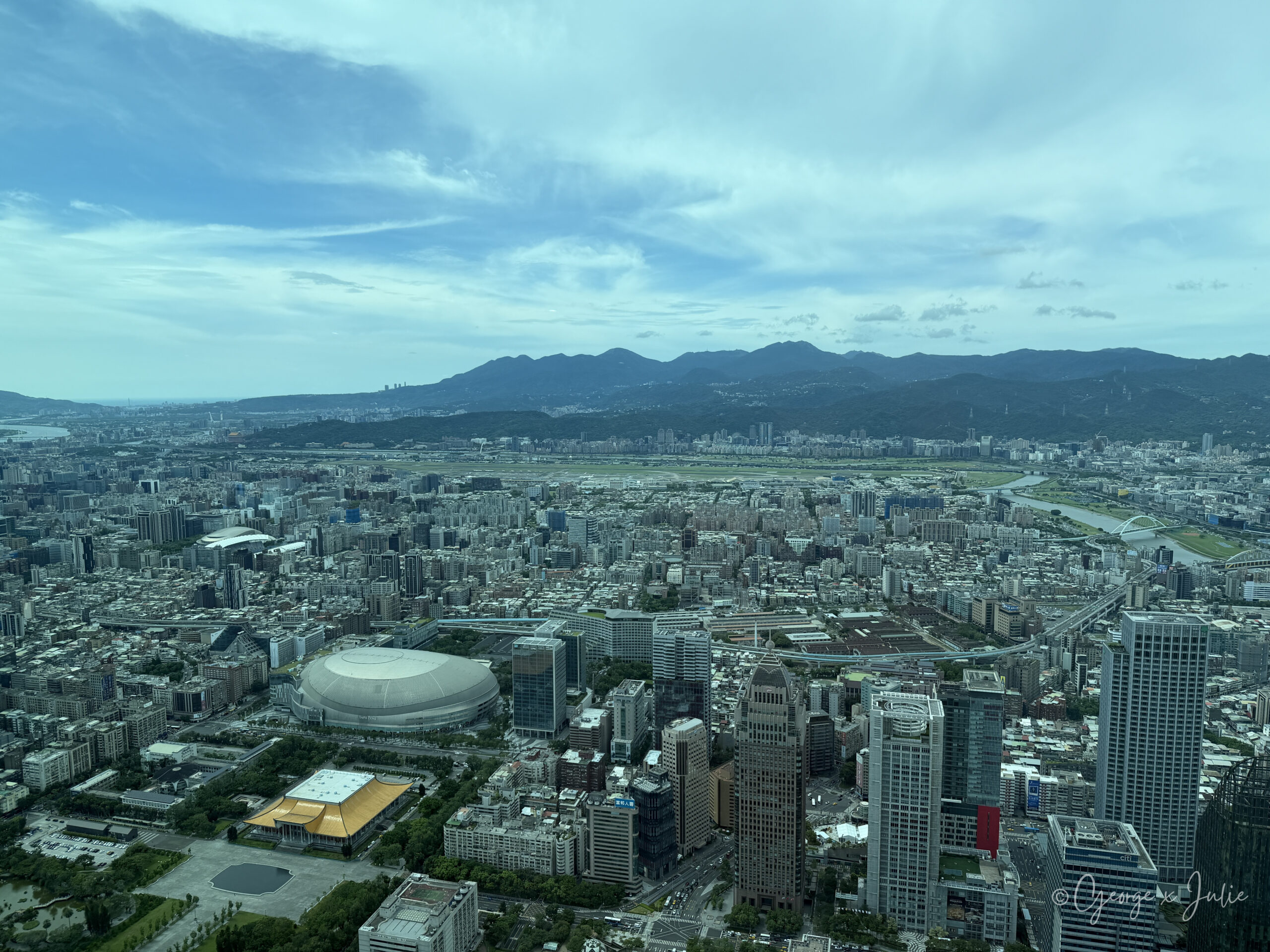 台北101觀景台窗外的市景、河道與遠山