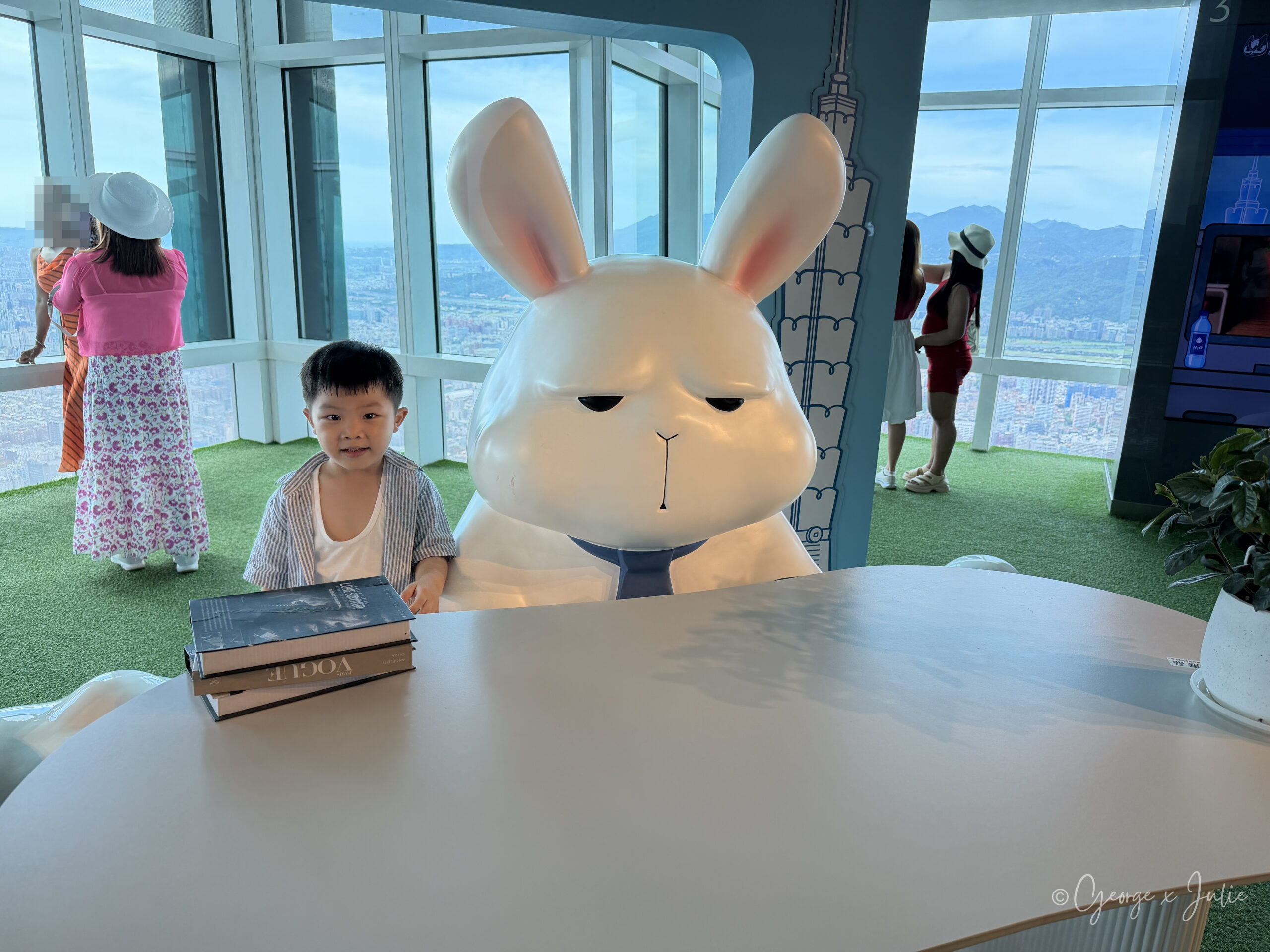 Jensen 坐在布魯斯特展的白色桌子前